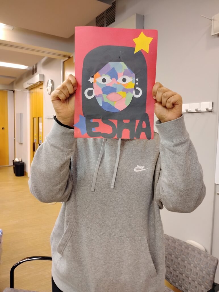 person holding a collage portrait in front of thieir face